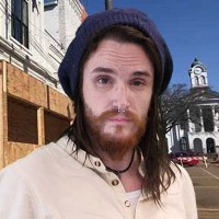 Heath Rushing Young man with long dark hair and scruffy beard